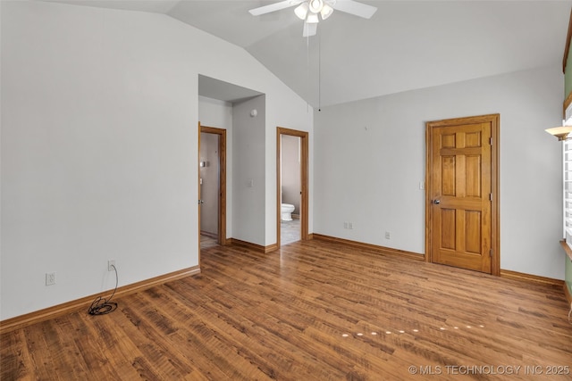 unfurnished room with a ceiling fan, vaulted ceiling, baseboards, and wood finished floors