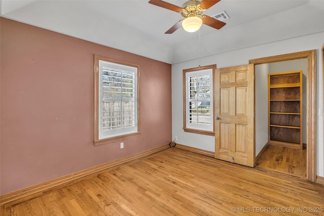 unfurnished bedroom featuring light wood-style floors, multiple windows, and visible vents