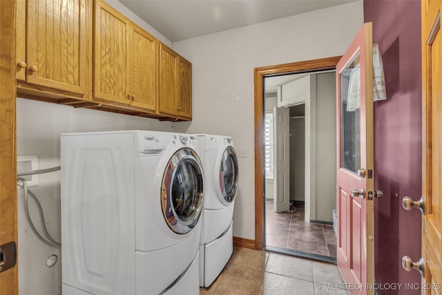 laundry area featuring cabinet space, light tile patterned floors, baseboards, and independent washer and dryer