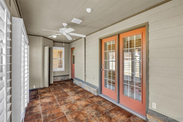 unfurnished sunroom with visible vents, a ceiling fan, and french doors