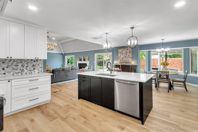 kitchen featuring light countertops, white cabinetry, a sink, light wood-type flooring, and dishwasher