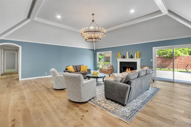 living room featuring light wood-style floors, arched walkways, visible vents, and a lit fireplace