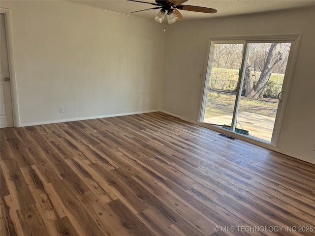 unfurnished room with ceiling fan, a textured ceiling, wood finished floors, visible vents, and baseboards