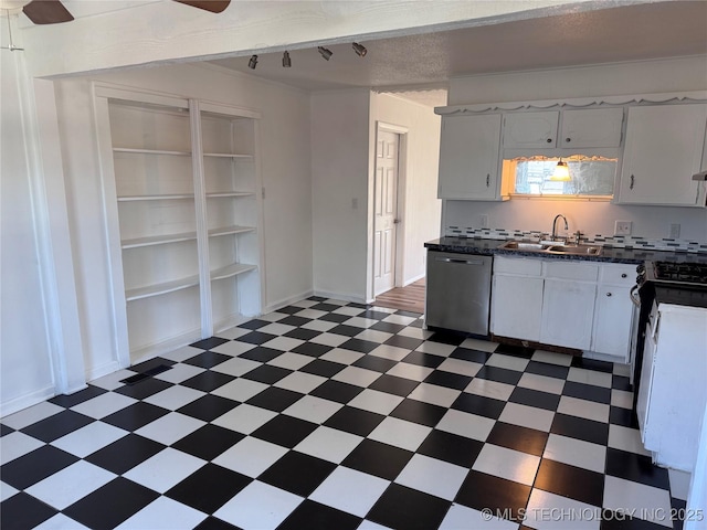 kitchen with dark countertops, dark floors, stainless steel appliances, white cabinetry, and a sink