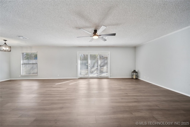 spare room with a wealth of natural light, visible vents, crown molding, and wood finished floors