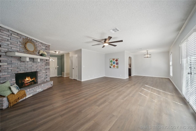 unfurnished living room featuring visible vents, a brick fireplace, crown molding, and wood finished floors