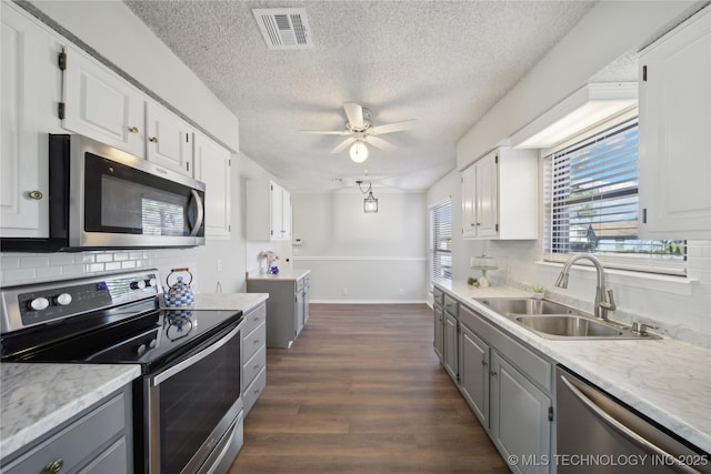 kitchen with visible vents, gray cabinetry, a sink, white cabinetry, and stainless steel appliances