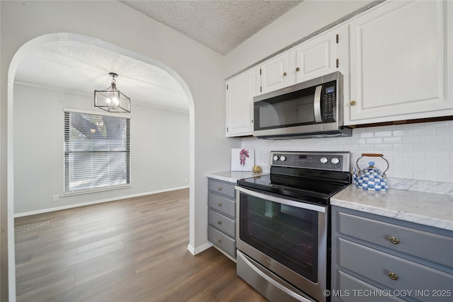 kitchen featuring dark wood finished floors, white cabinets, appliances with stainless steel finishes, and gray cabinetry