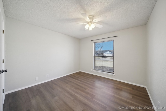 spare room featuring dark wood finished floors, a textured ceiling, baseboards, and a ceiling fan