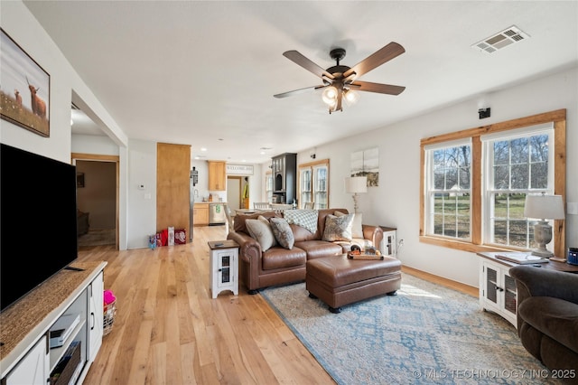 living area featuring a ceiling fan, light wood-type flooring, and visible vents