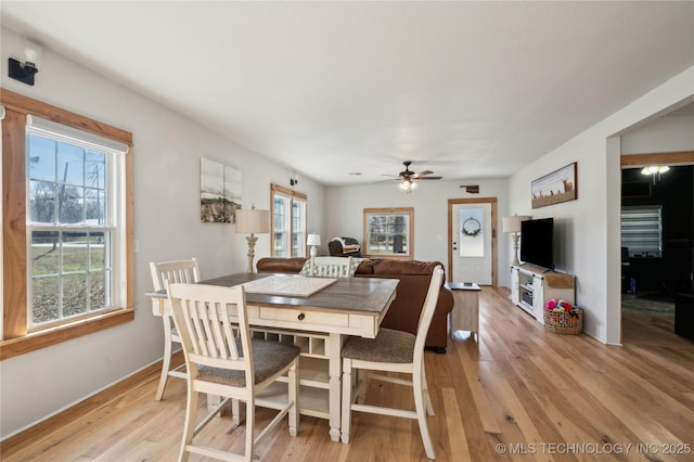 dining room with a healthy amount of sunlight, light wood-style floors, ceiling fan, and baseboards