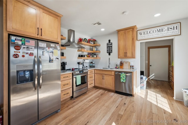 kitchen featuring visible vents, light wood-style floors, stainless steel appliances, light countertops, and wall chimney range hood