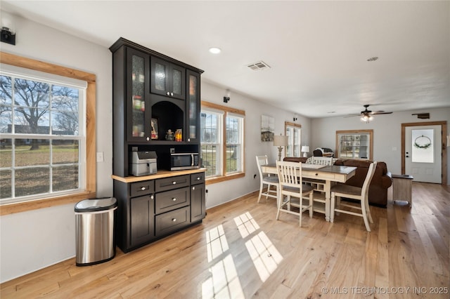 dining room with a wealth of natural light, visible vents, light wood finished floors, and recessed lighting