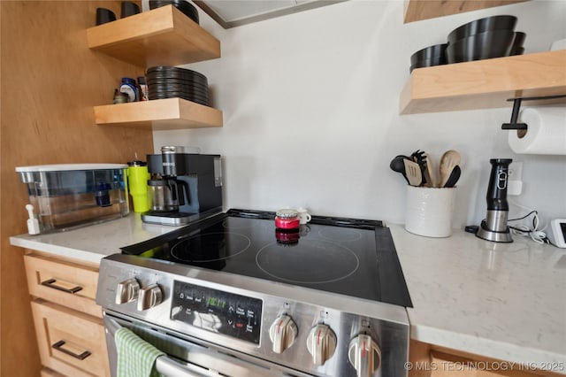 kitchen with open shelves and stainless steel range with electric stovetop