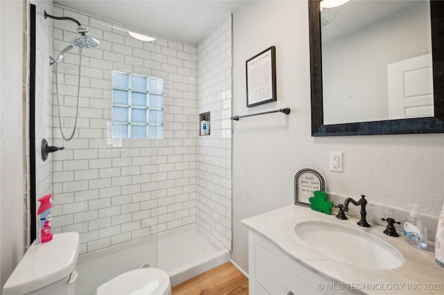 bathroom featuring a shower stall, toilet, and vanity