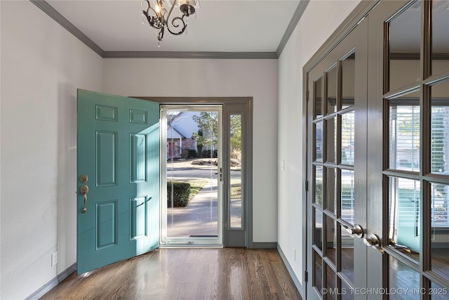 foyer featuring baseboards, a notable chandelier, ornamental molding, and wood finished floors