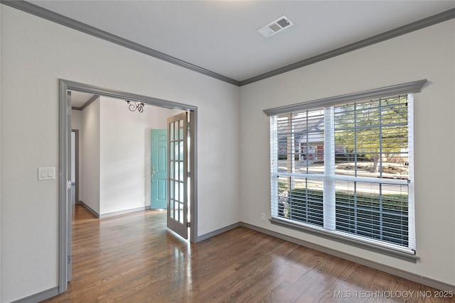 unfurnished room with french doors, visible vents, ornamental molding, wood finished floors, and baseboards