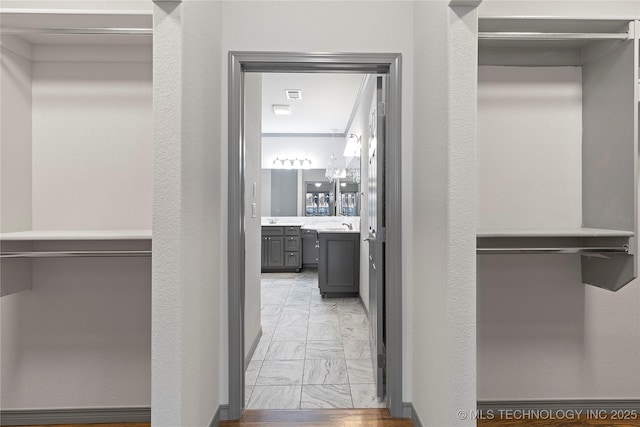 walk in closet with marble finish floor and visible vents