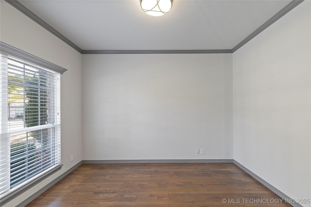 spare room featuring dark wood-style floors, baseboards, and crown molding