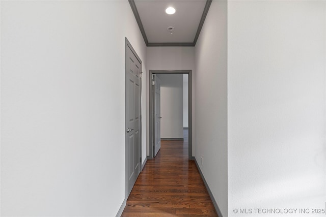 hallway featuring crown molding, baseboards, and dark wood-style flooring