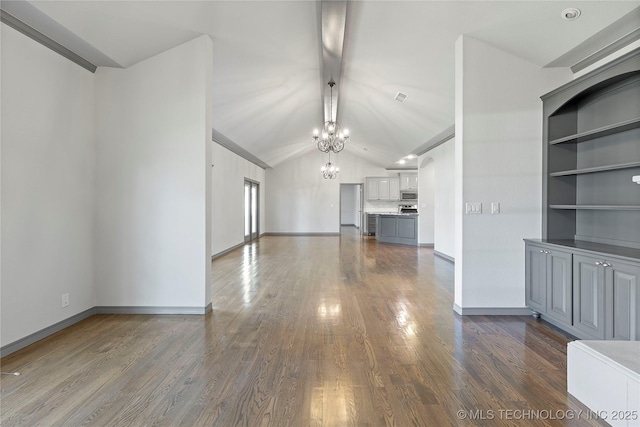 unfurnished living room with dark wood-style floors, vaulted ceiling, a chandelier, and baseboards