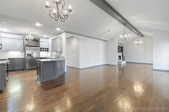 kitchen with lofted ceiling with beams, decorative backsplash, gray cabinetry, an inviting chandelier, and stainless steel fridge with ice dispenser