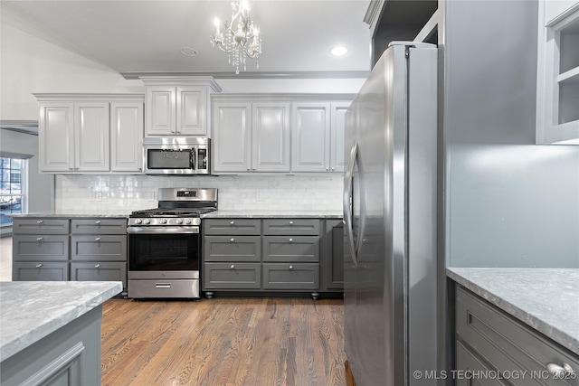 kitchen with dark wood-style flooring, gray cabinets, decorative backsplash, appliances with stainless steel finishes, and white cabinetry