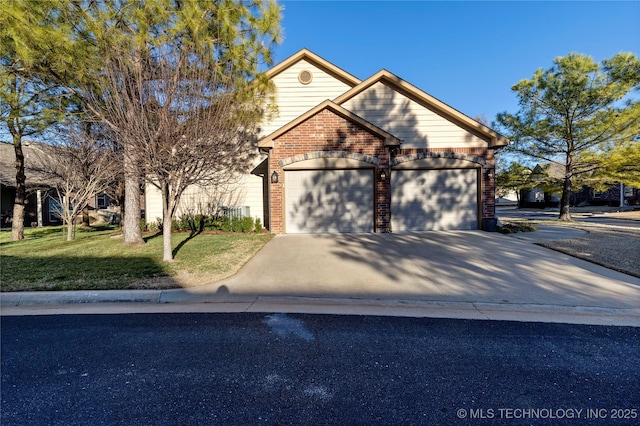 view of front of house with an attached garage, concrete driveway, brick siding, and a front yard