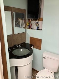 bathroom with backsplash, toilet, and vanity