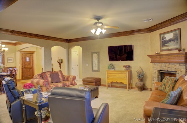 living area featuring carpet floors, arched walkways, a fireplace, visible vents, and ornamental molding