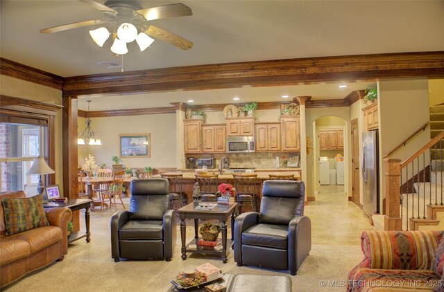 living area with stairway, visible vents, arched walkways, and ornamental molding