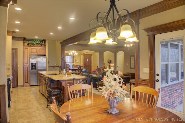 dining room featuring a chandelier, arched walkways, light tile patterned floors, and recessed lighting