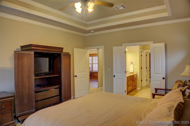 bedroom featuring a tray ceiling, visible vents, and crown molding