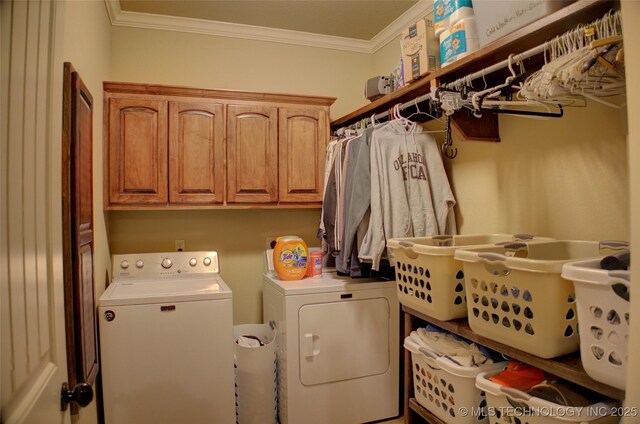 laundry room with ornamental molding, washing machine and dryer, and cabinet space