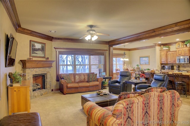 living area featuring light colored carpet, visible vents, ornamental molding, ceiling fan, and a stone fireplace