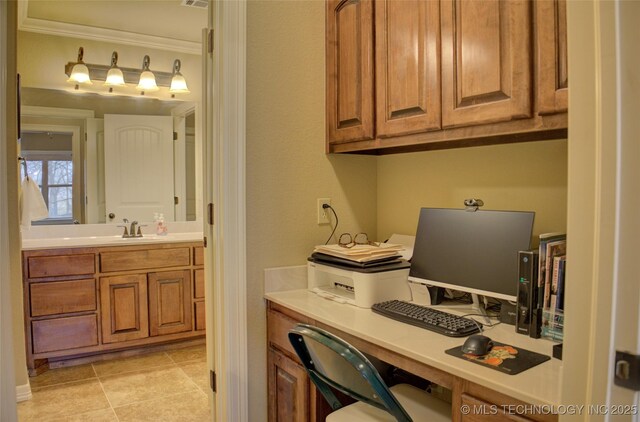 office space with ornamental molding, built in study area, a sink, and light tile patterned floors