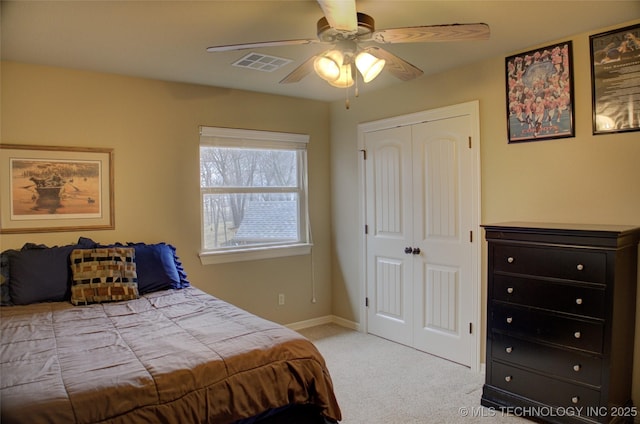 bedroom featuring ceiling fan, light colored carpet, visible vents, baseboards, and a closet