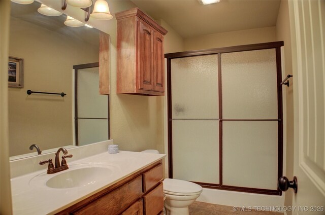 full bathroom with toilet, a stall shower, and vanity