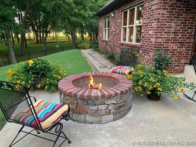 view of patio / terrace with a fire pit and fence