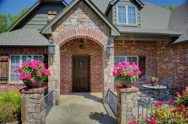 3402 Harbour Town Pl, Claremore, OK 74019 - doorway to property featuring a shingled roof, brick siding, and stone siding