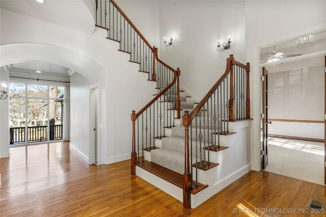 11630 S Fulton Ave, Tulsa, OK 74137 - stairway with wood finished floors, arched walkways, a ceiling fan, and baseboards