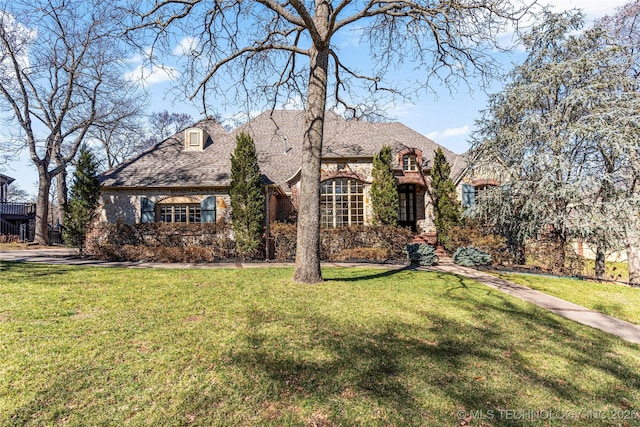 view of front of property featuring brick siding and a front lawn