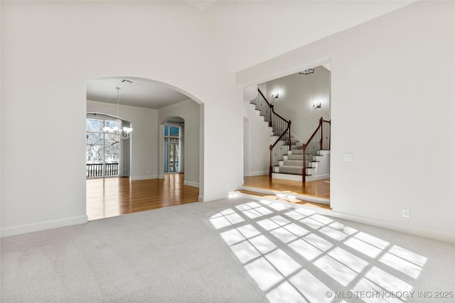 11630 S Fulton Ave, Tulsa, OK 74137 - empty room featuring a chandelier, carpet flooring, arched walkways, ornamental molding, and baseboards