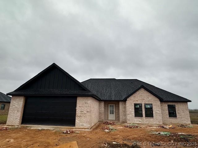 view of front facade featuring board and batten siding, brick siding, and a garage