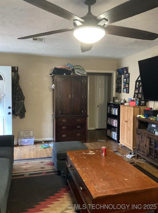 living room with dark wood-style flooring and a ceiling fan