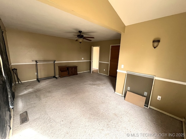 unfurnished room featuring carpet floors, lofted ceiling, visible vents, a ceiling fan, and baseboards