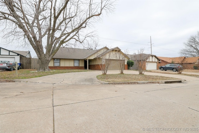 view of front of home featuring concrete driveway, fence, and an attached garage