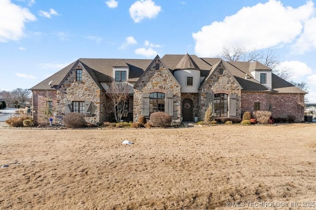 french provincial home with stone siding and brick siding