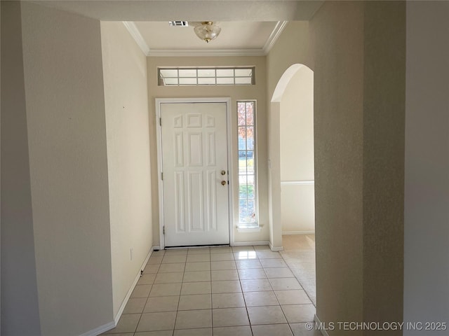 foyer entrance featuring arched walkways, crown molding, baseboards, and light tile patterned floors