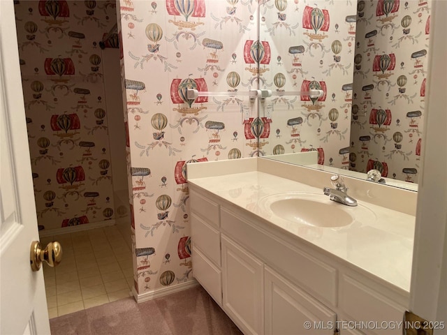 full bathroom with baseboards, wallpapered walls, vanity, and tile patterned floors